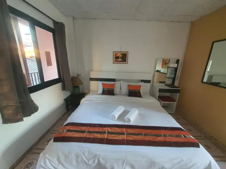 Rincón de habitación de Forge Boutique Chiang Mai con cama, sillas, minibar y aire acondicionado