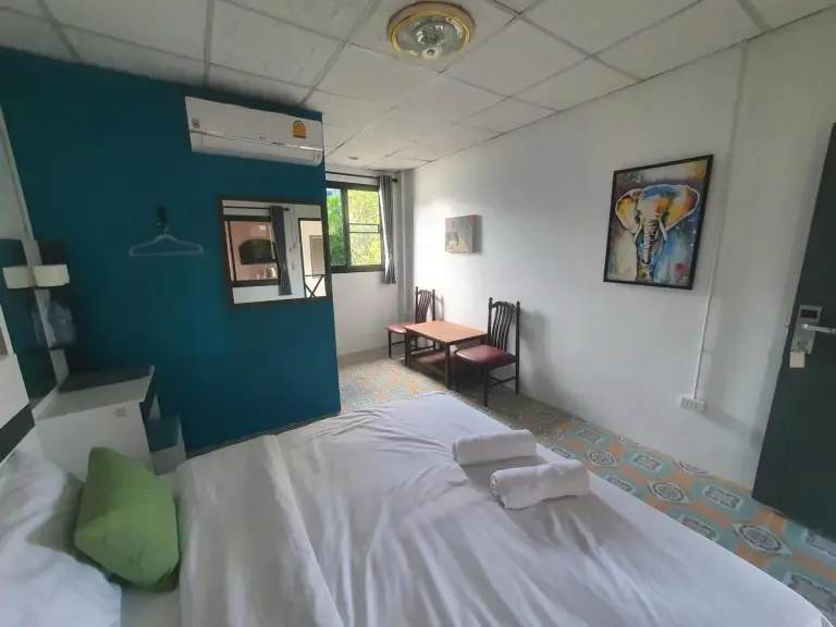 Habitación doble de huéspedes de Forge Boutique Chiang Mai con cama, escritorio y decoración colorida