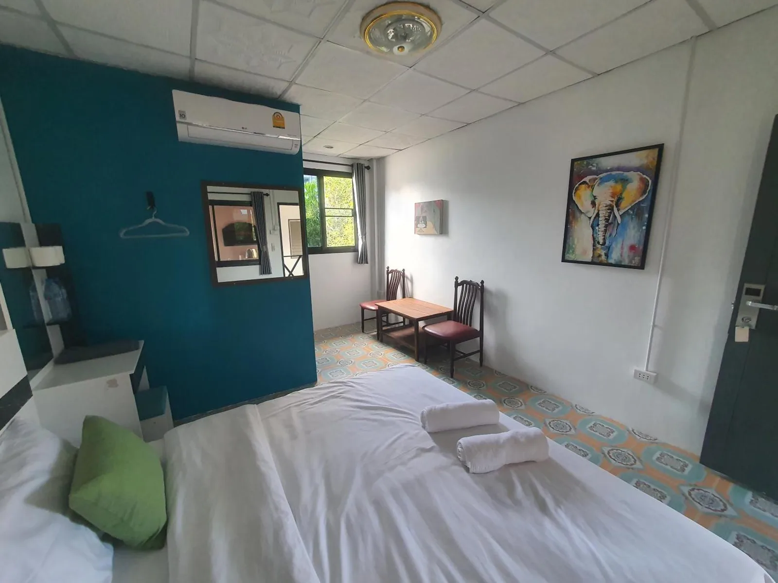 Habitación doble de huéspedes de Forge Boutique Chiang Mai con cama, escritorio y decoración colorida