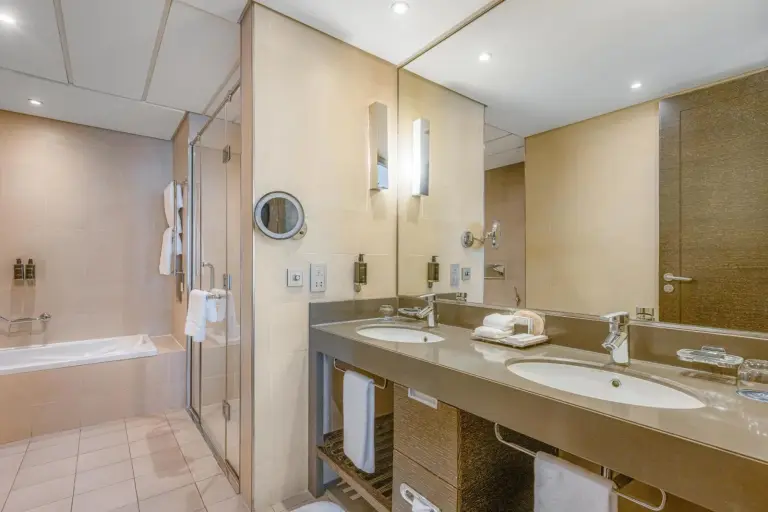 Modern bathroom at Four Points by Sheraton Al Ain with bathtub, glass shower, and vanity