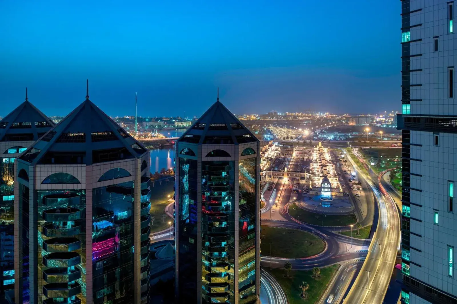 Night city view from Four Points by Sheraton Sharjah overlooking illuminated towers and roads.