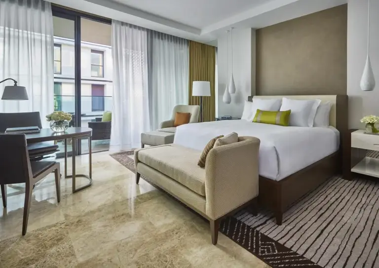Interior of a guest room at the Four Seasons Hotel Casablanca with a king bed and seating area