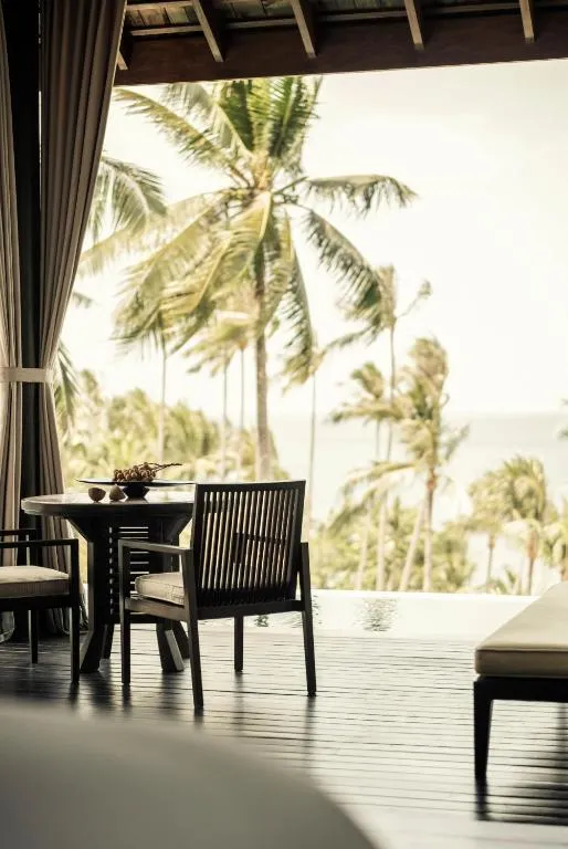 Four Seasons Resort Koh Samui – Koh Samui, Thailand hotel – a dining room with a table and chairs and palm trees at Four Seasons Resort Koh Samui in Mae Nam