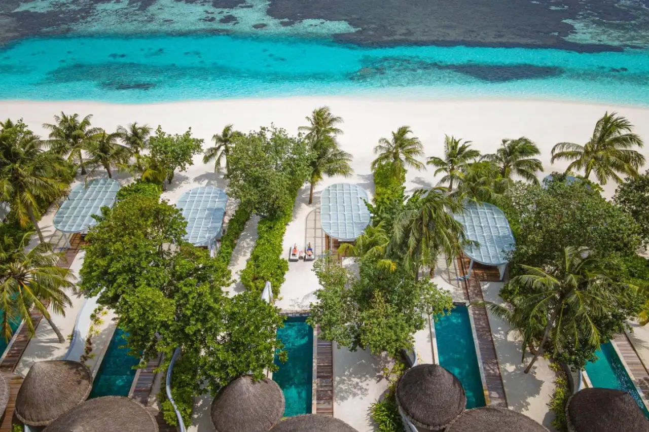 Beach Cabanas im Four Seasons Resort Maldives in Kuda Huraa, umgeben von Palmen.