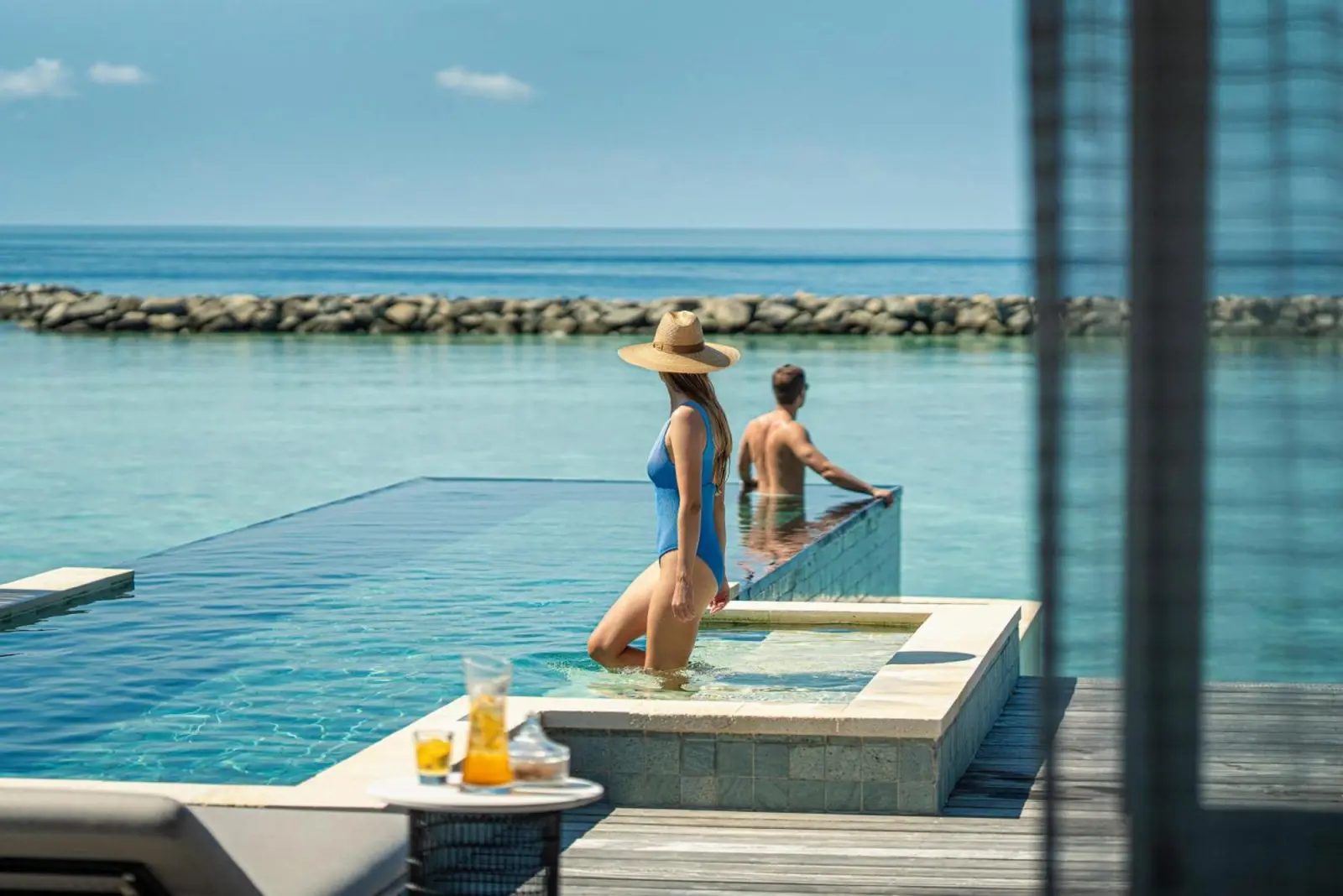Couple enjoying pool at Four Seasons Resort Maldives at Landaa Giraavaru