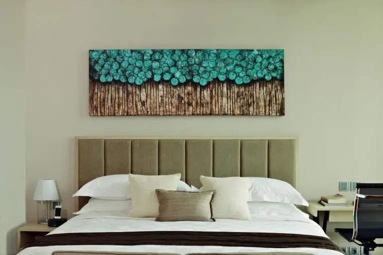 Dormitorio en Fraser Residence Menteng Jakarta con cabecero tapizado y arte mural