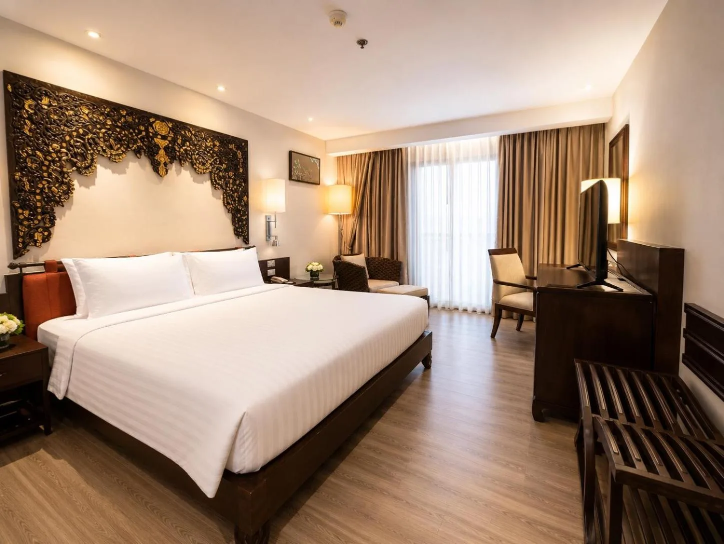 Chambre deluxe spacieuse au Garden Cliff Resort And Spa à Pattaya avec un lit king-size, un bureau et des portes donnant sur le balcon