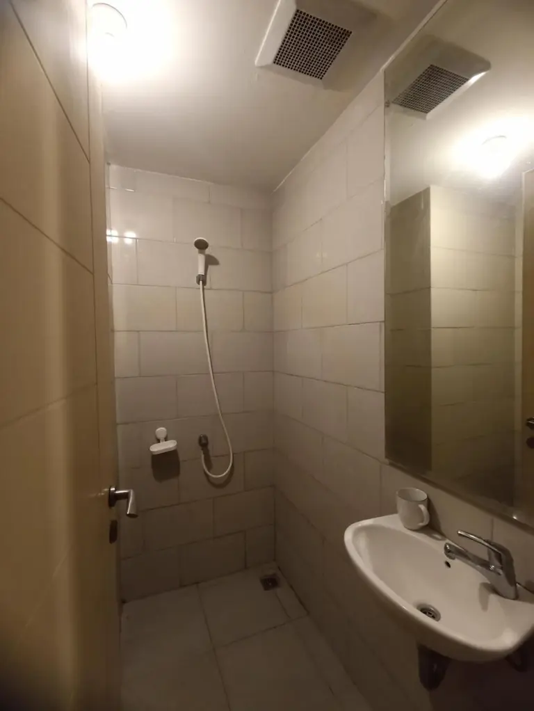 Gatotkaca Hotels Surabaya bathroom with shower, sink, and mirror