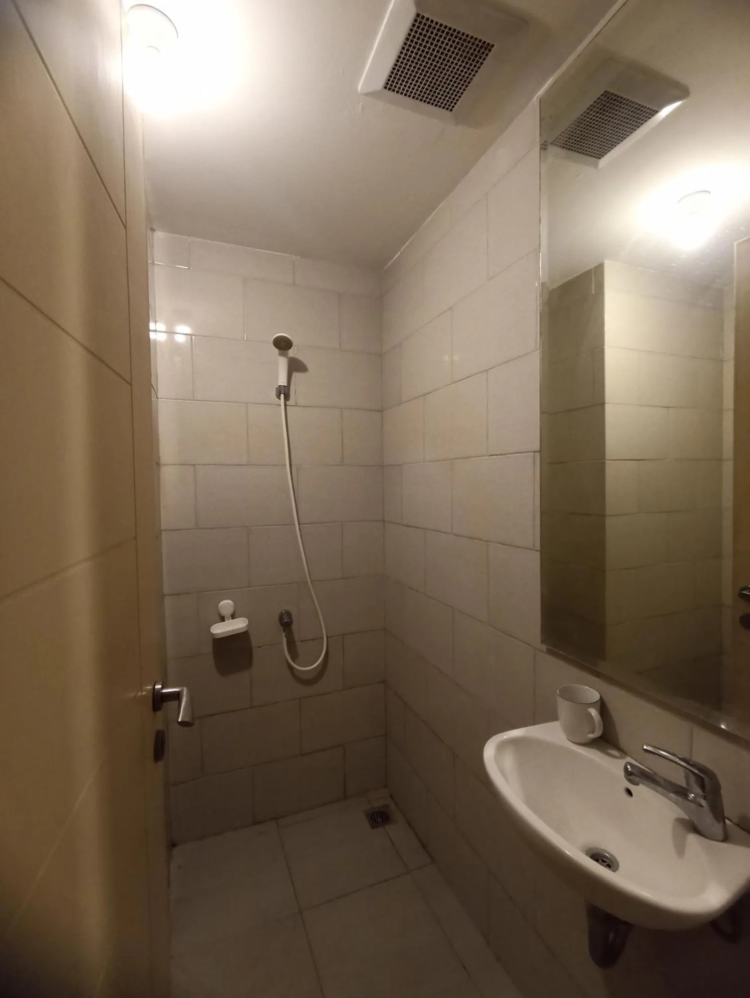 Gatotkaca Hotels Surabaya bathroom with shower, sink, and mirror