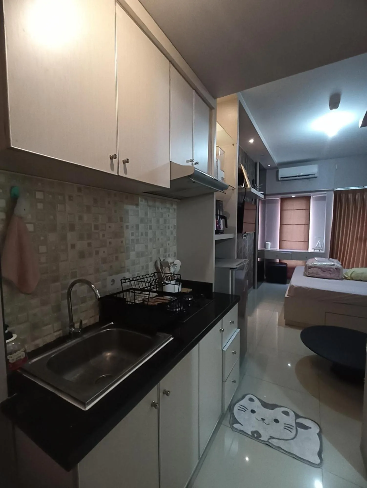 Gatotkaca Hotels Surabaya kitchenette with sink, counter, and cabinets in a studio room