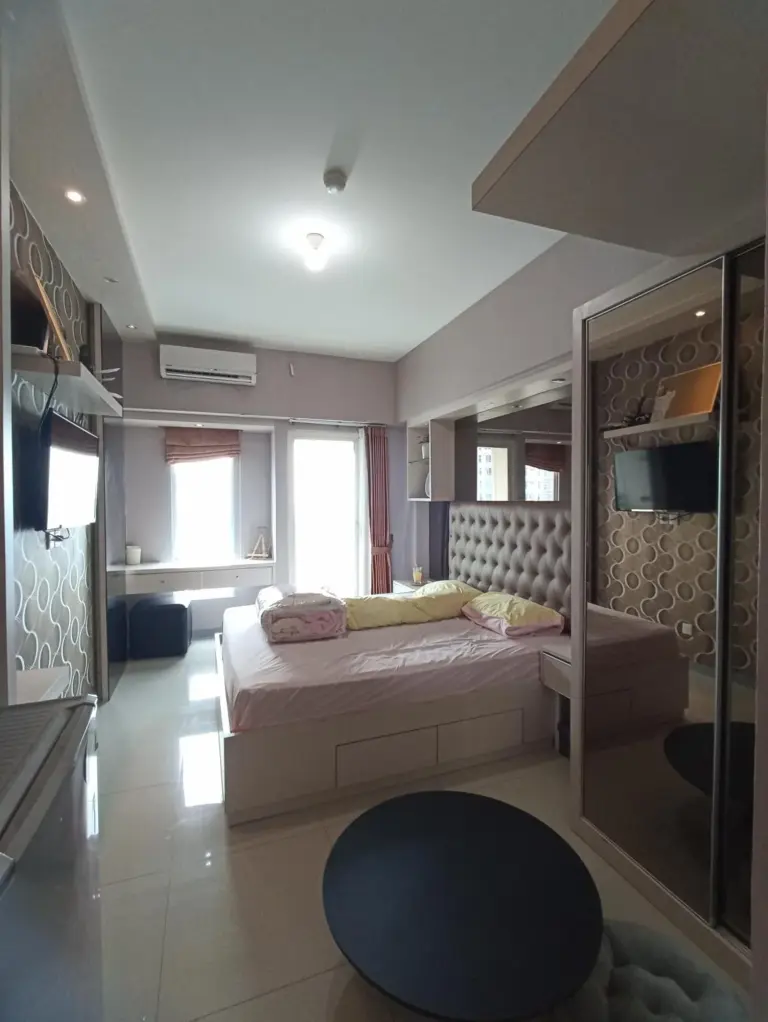 Gatotkaca Hotels Surabaya studio bedroom with a bed, desk, TV, and modern furnishings