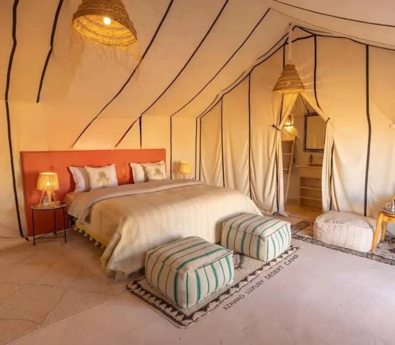Global Luxury Camp in Merzouga double suite with large bed and decorative ottomans