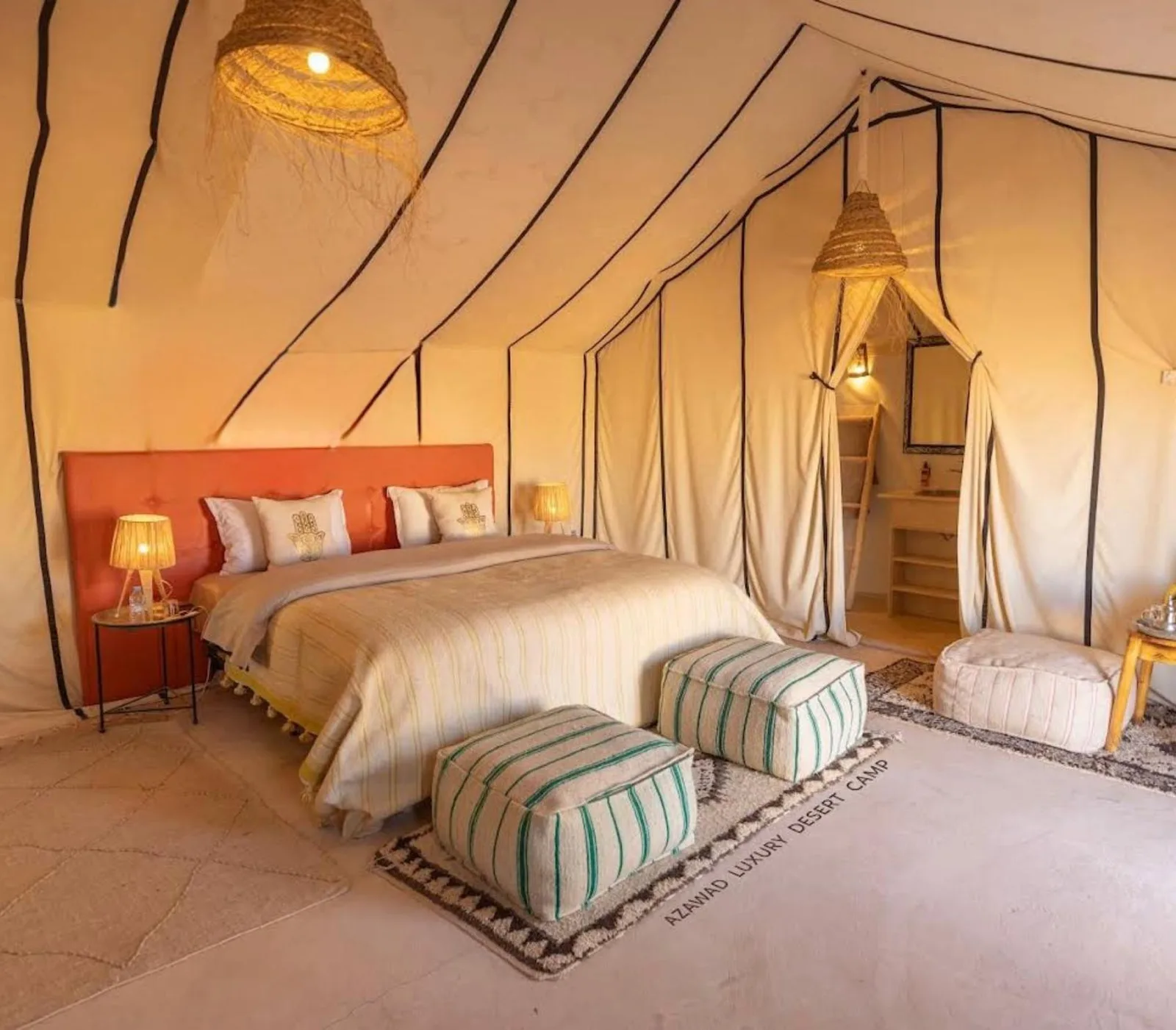 Global Luxury Camp in Merzouga double suite with large bed and decorative ottomans
