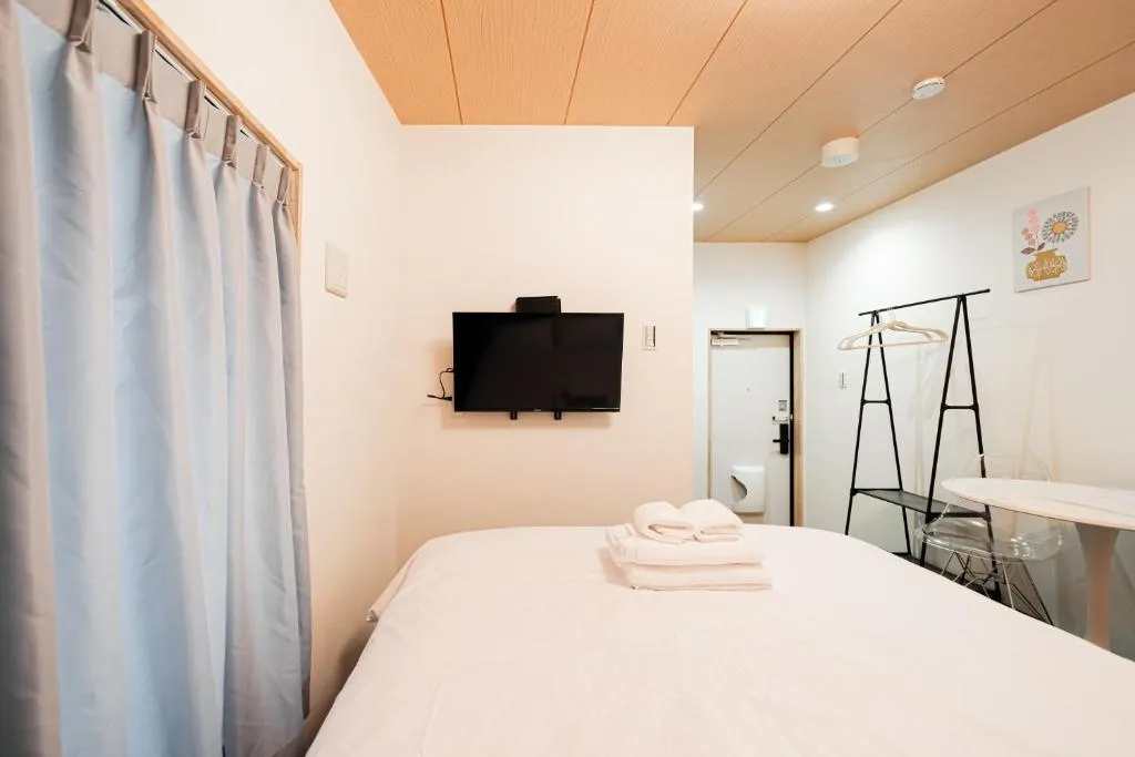 Chambre d'hôte avec une télévision au GLOU Akasaka Inn à Tokyo.