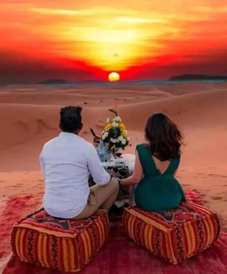 Romantic desert dinner experience at Golden Dunes Luxury Camp in Merzouga during a sunset over the dunes.
