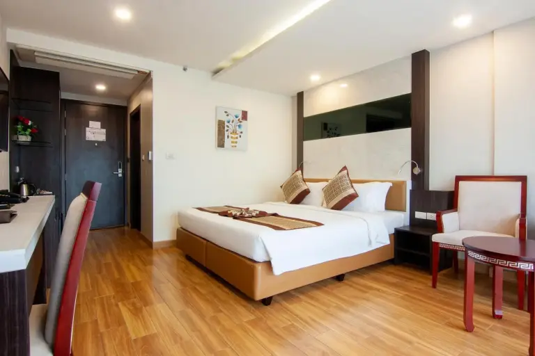 Modern bathroom at Golden Jomtien Beach Hotel in Pattaya with glass shower, toilet, and vanity.