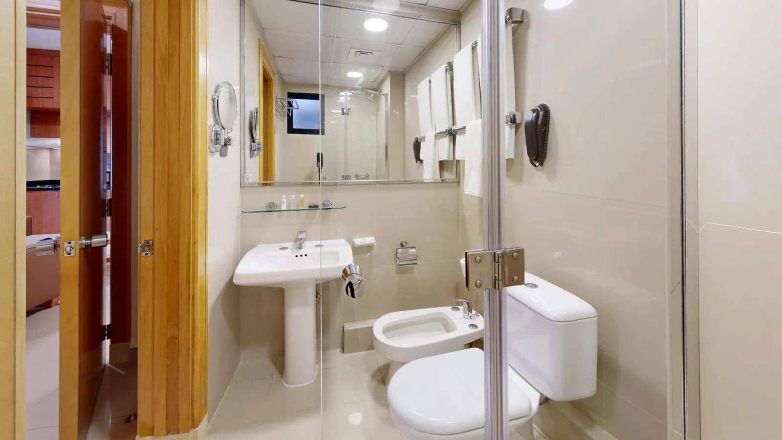 Golden Sands Hotel Apartments Dubai salle de bains avec lavabo, toilettes, bidet et cabine de douche vitrée