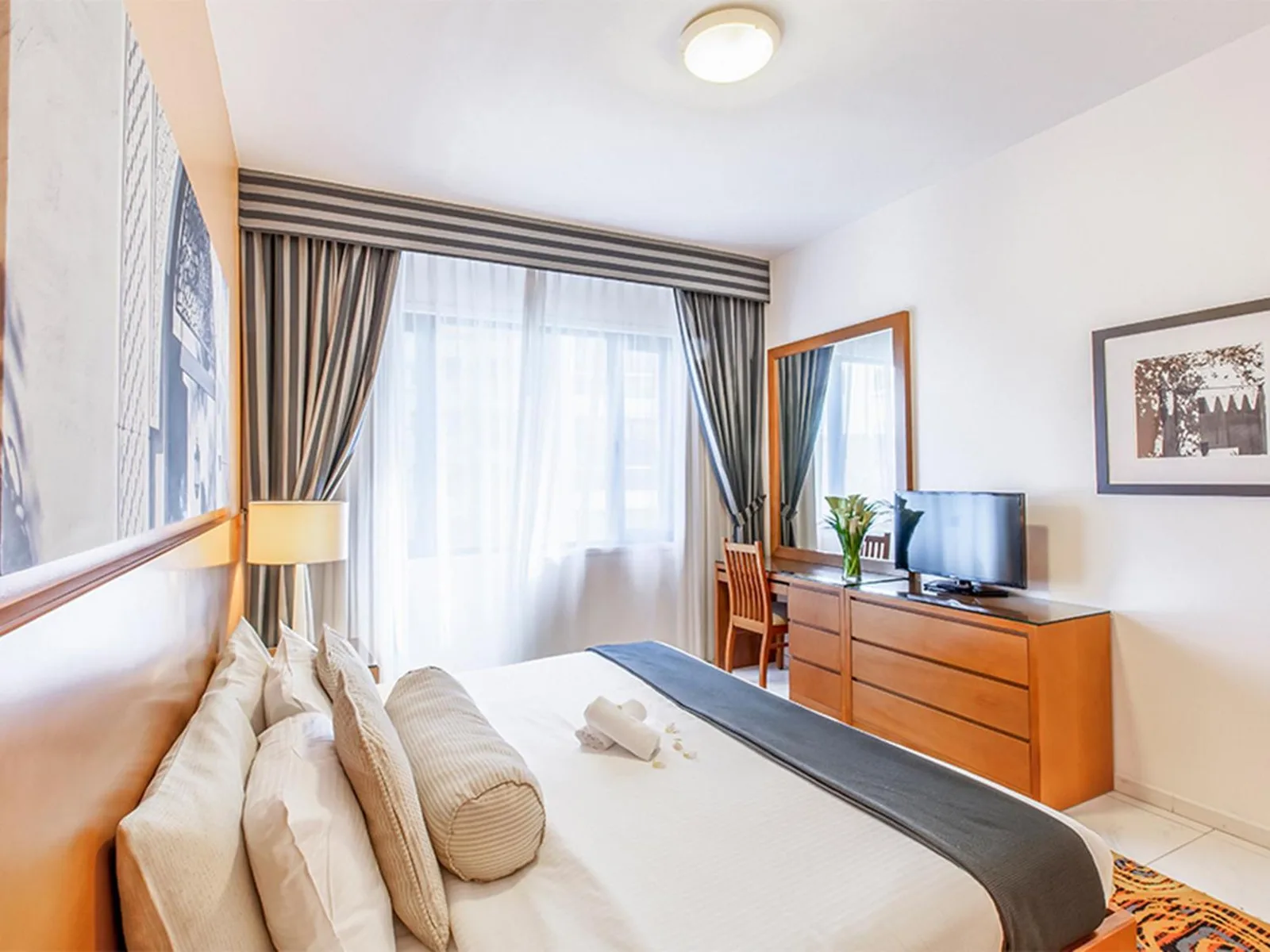 Golden Sands Hotel Apartments Dubai chambre avec grand lit, télévision, commode et fenêtre lumineuse