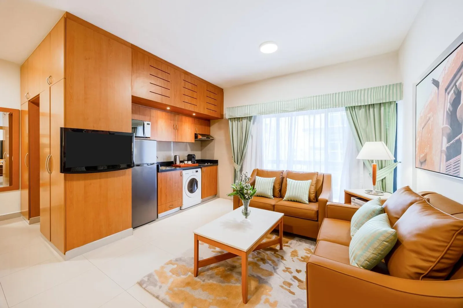 Golden Sands Hotel Apartments Dubai coin salon avec canapés, table basse, kitchenette et banquette près de la fenêtre