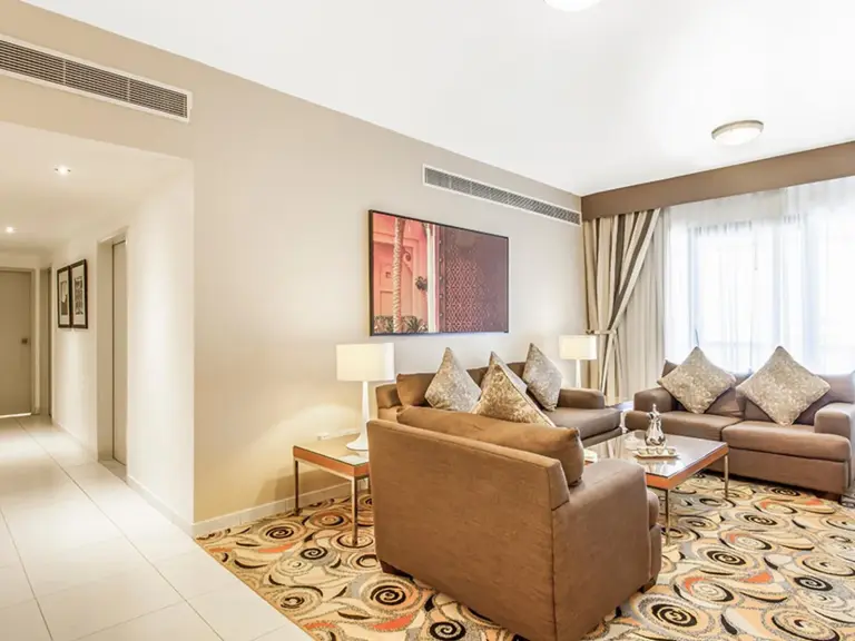 Golden Sands Hotel Apartments Dubai salon avec canapés, fauteuil, table basse et tapis à motifs
