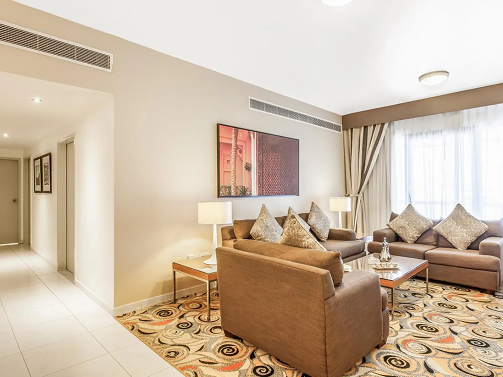 Golden Sands Hotel Apartments Dubai salon avec canapés, fauteuil, table basse et tapis à motifs