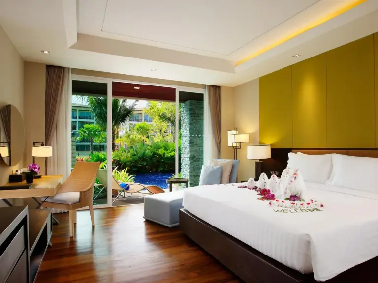 Habitación con vistas a la piscina en Graceland Khaolak Beachfront Resort con cama king, zona de estar y vistas tropicales