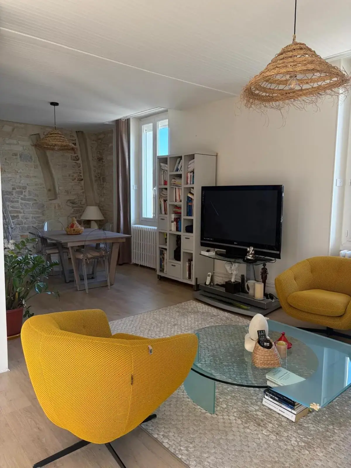 Grand Duplex spacieux en maison de ville – hotel en Dijon, Francia – un salón con un televisor, una mesa y sillas amarillas en Grand Duplex spacieux en maison de ville en Dijon