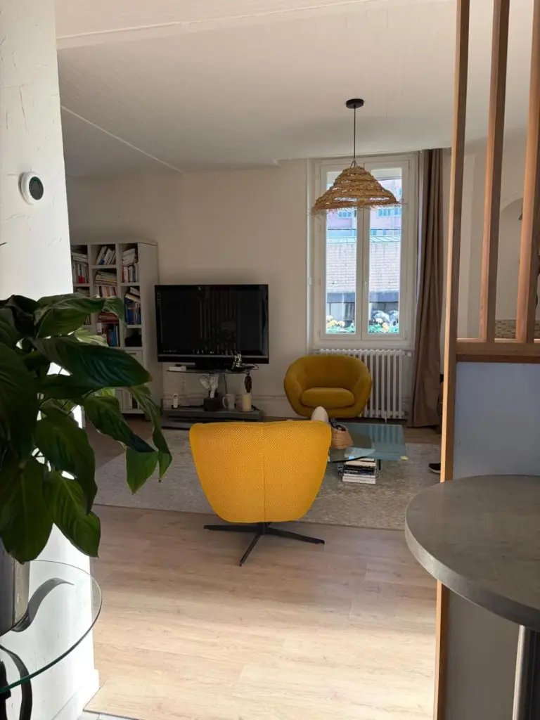 Grand Duplex spacieux en maison de ville – hotel en Dijon, Francia – un salón con una silla amarilla y un televisor en Grand Duplex spacieux en maison de ville en Dijon