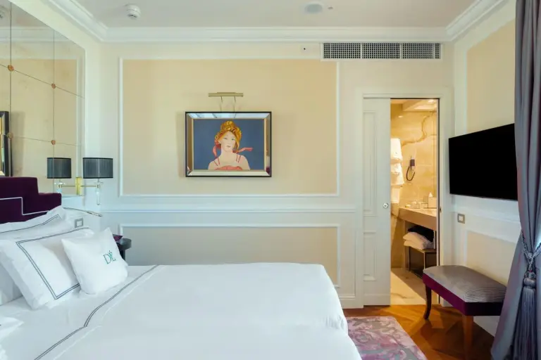 Charmantes Schlafzimmer im Grand Hotel Des Etrangers mit Kunstwerken und Zugang zum Badezimmer