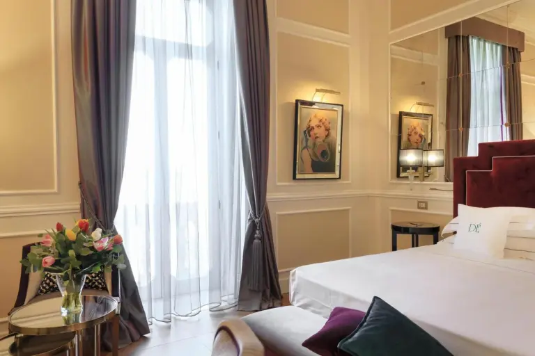 Einladendes Schlafzimmer mit Blumenarrangements im Grand Hotel Des Etrangers