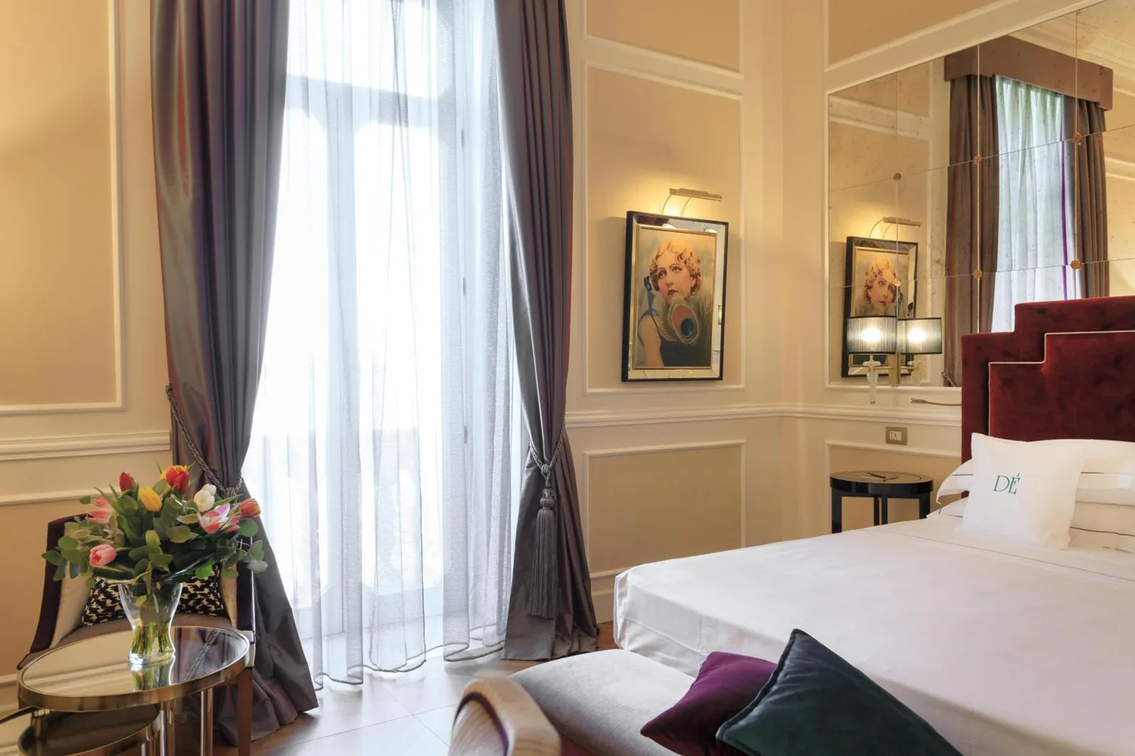 Einladendes Schlafzimmer mit Blumenarrangements im Grand Hotel Des Etrangers