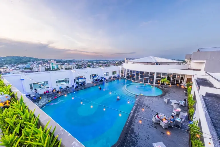 Rooftop pool deck at Grand Jatra Hotel Balikpapan in Balikpapan with a large swimming pool and lounge seating
