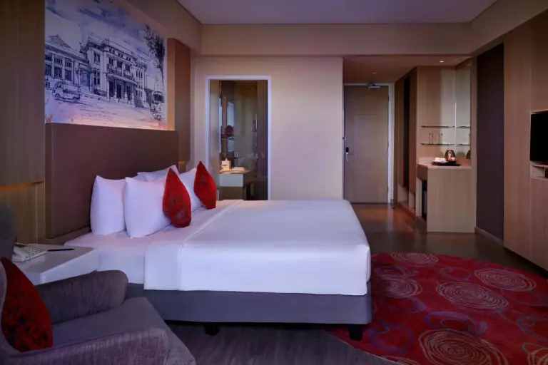 Guest room at Grand Mercure Bandung Setiabudi in Bandung with bed, bathroom access, and red patterned carpet