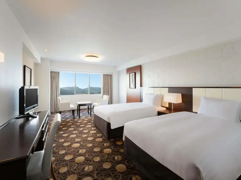 Grand Mercure Beppu Bay Resort & Spa – Hotel in Beppu, Japan – ein Hotelzimmer mit zwei Betten und einem Flachbildfernseher im Grand Mercure Beppu Bay Resort & Spa in Beppu