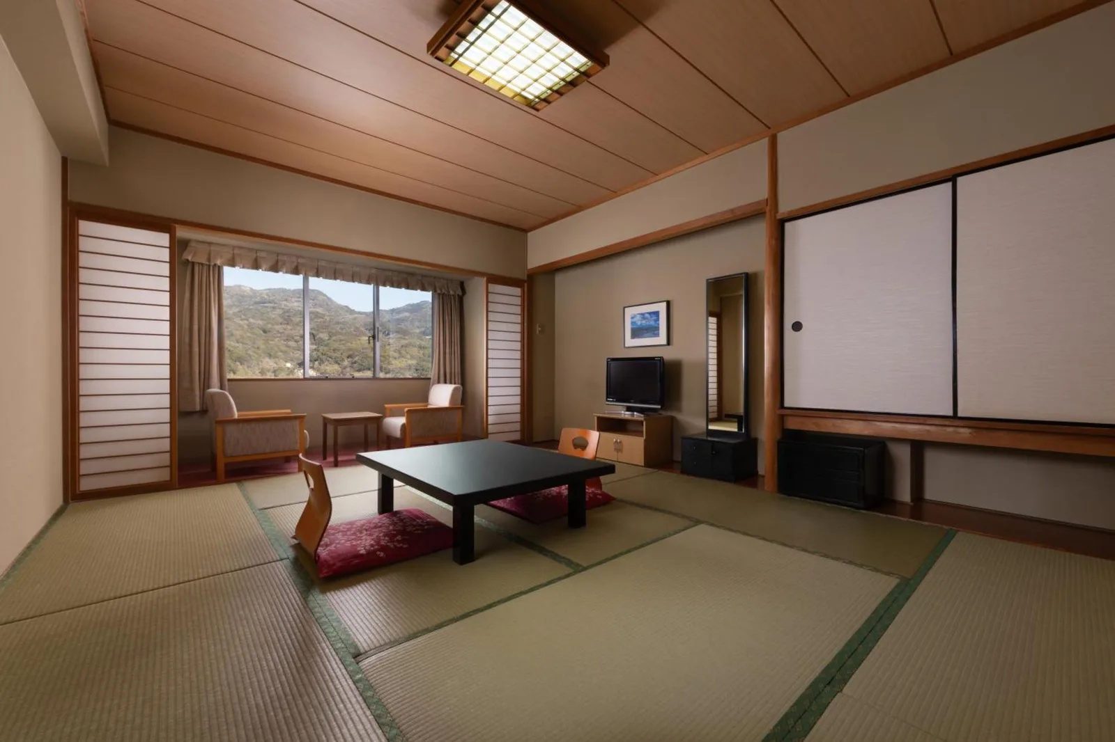 Grand Mercure Beppu Bay Resort & Spa – Hotel in Beppu, Japan – ein Wohnzimmer mit einem Tisch und einem großen Fenster im Grand Mercure Beppu Bay Resort & Spa in Beppu