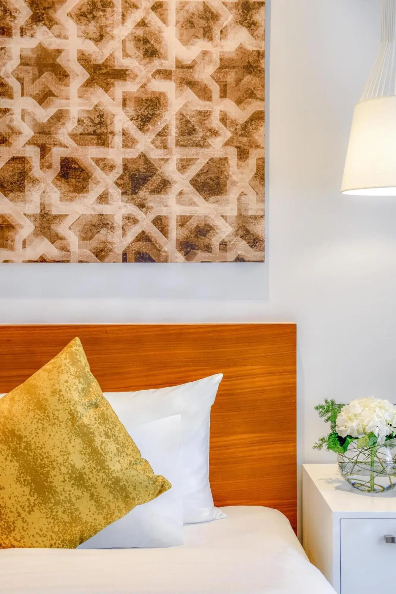 Bett-Detail im Grand Mercure Dubai City mit Kunstwerk, Lampe und Nachttisch