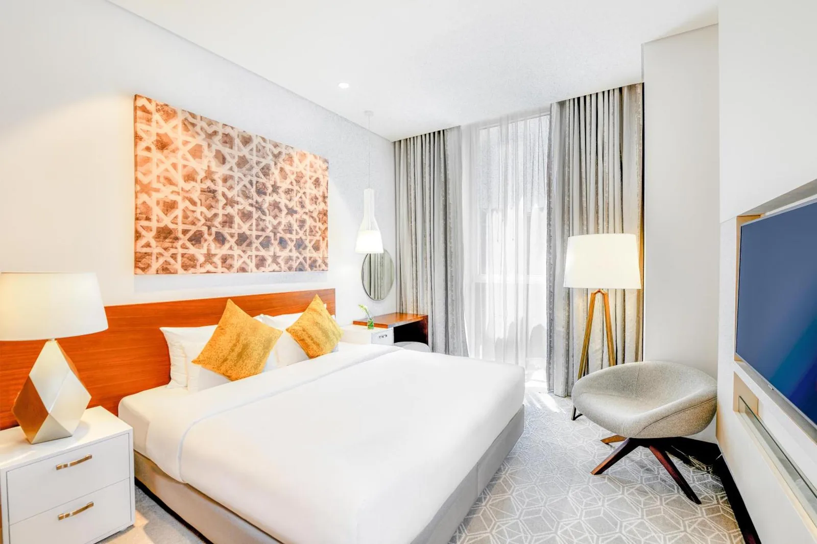 Hotelzimmer im Grand Mercure Dubai City mit Kingsize-Bett, Sitzbereich und bodentiefen Vorhängen