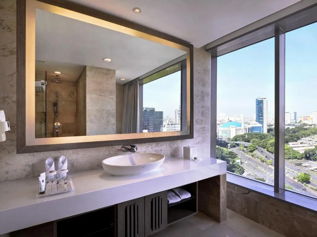Badezimmer mit atemberaubendem Stadtblick im Grand Mercure Jakarta Kemayoran