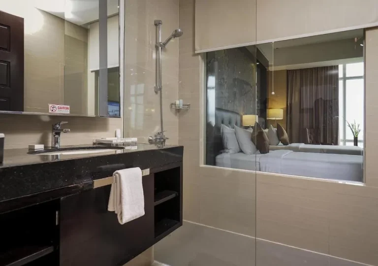 Grand Mercure Solo Baru – Surakarta, Indonesia hotel – a bathroom with a sink and a shower and a bed at Grand Mercure Solo Baru in Solo