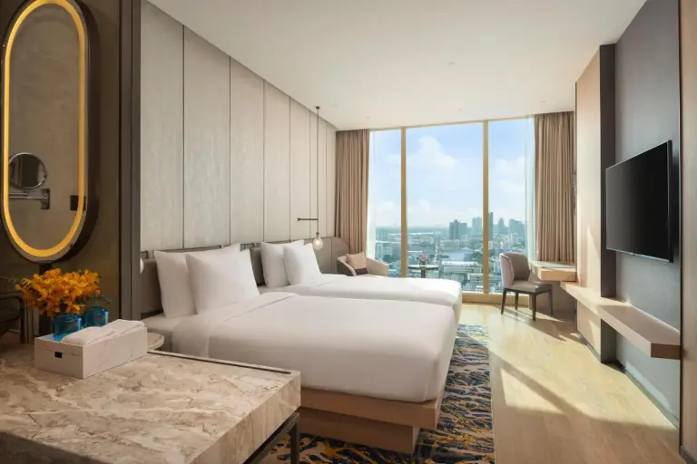 Grand Nikko Bangkok Sathorn – Hotel in Bangkok, Thailand – ein Schlafzimmer mit einem großen weißen Bett und einem Fernseher im Grand Nikko Bangkok Sathorn in Bangkok