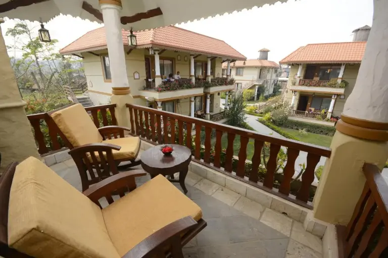 Balcon donnant sur le jardin avec chaises longues à l’hôtel Green Park Chitwan à Sauraha.
