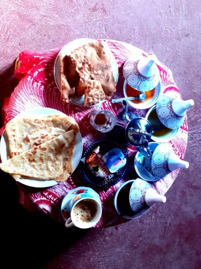 Breakfast tea and flatbread served on a round table at Guests House in Merzouga.
