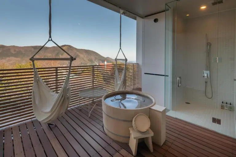 Outdoor bathing area with hot tub at Hakone Honbako