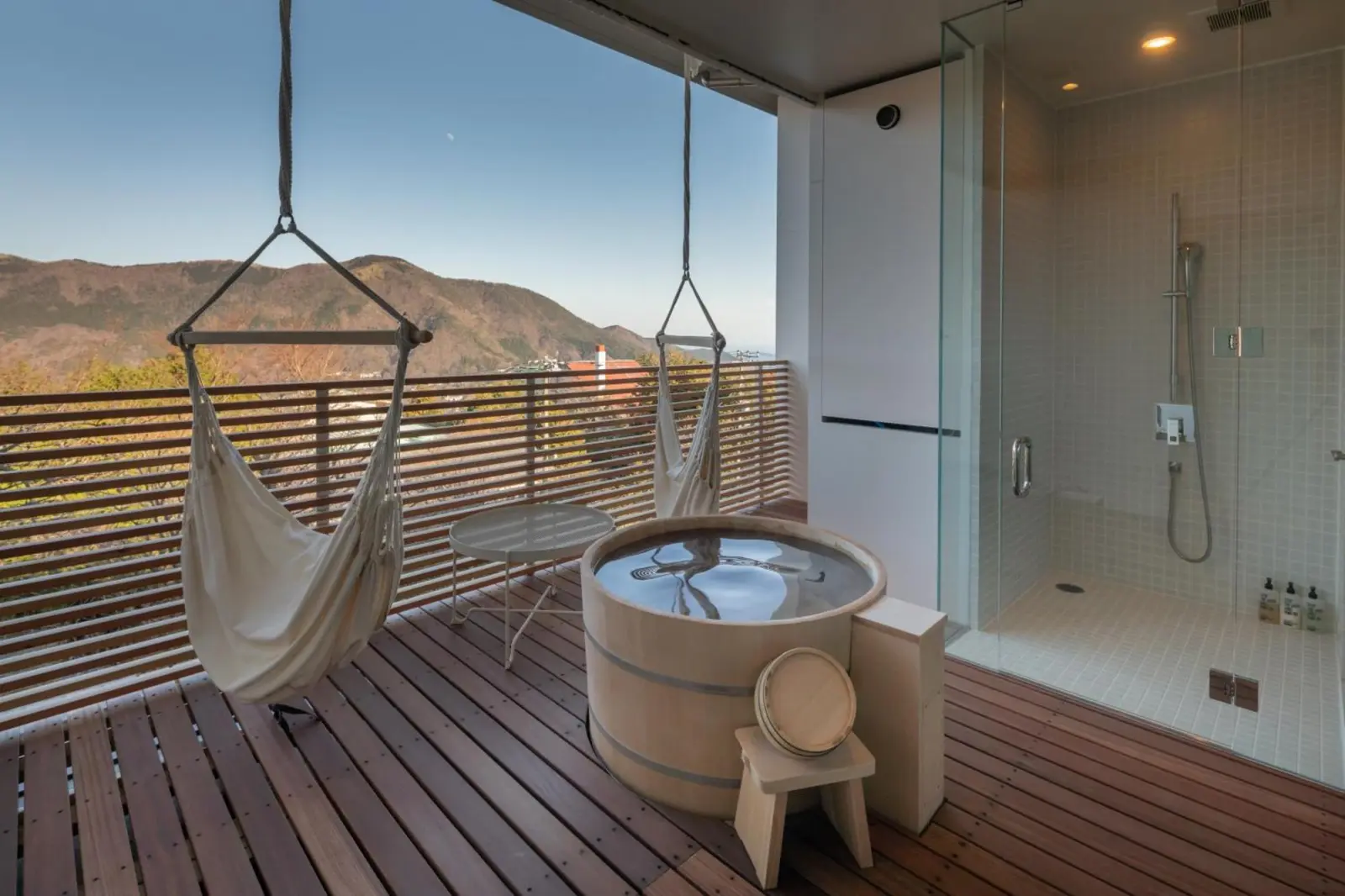 Outdoor bathing area with hot tub at Hakone Honbako