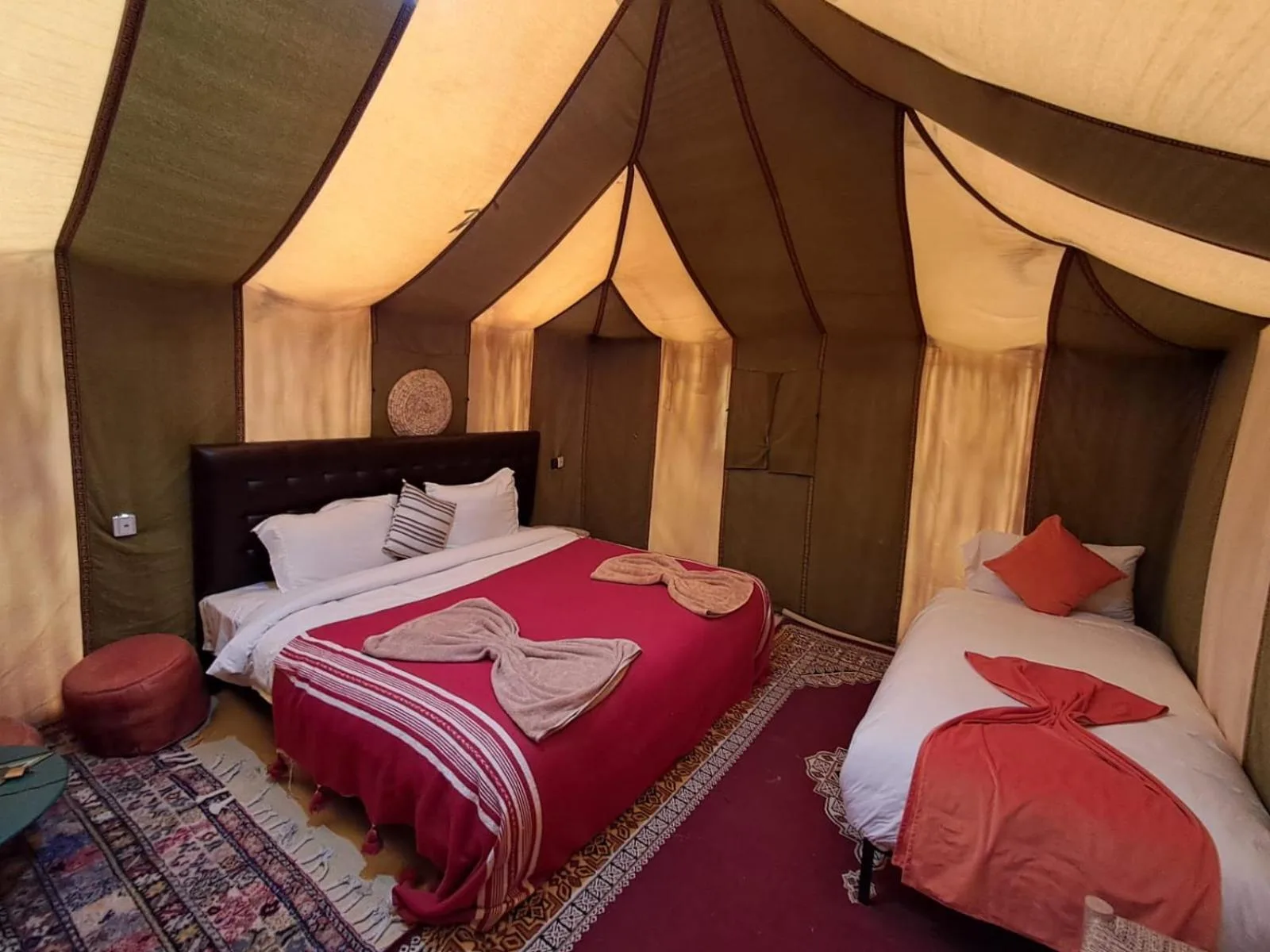 a bedroom with two beds and a dress on at Hassan desert camp in Merzouga