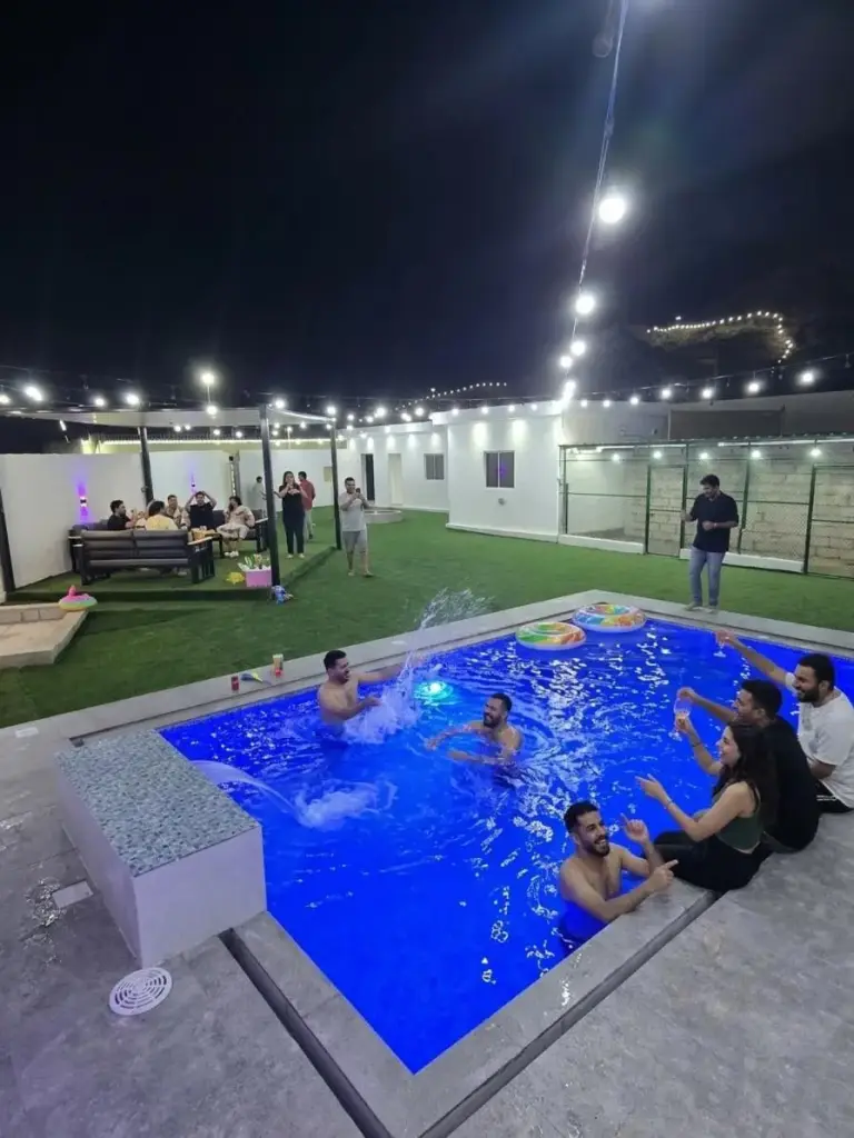 Guests enjoying a night pool party at Hatta Romance Chalet
