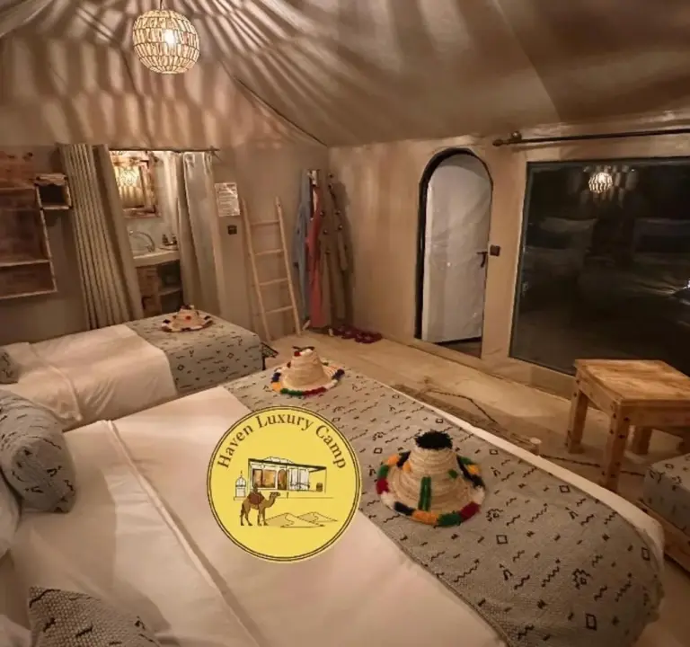 Haven Luxury Camp – Merzouga, Maroc hôtel – une chambre avec deux lits et un panneau dessus au Haven Luxury Camp à Merzouga
