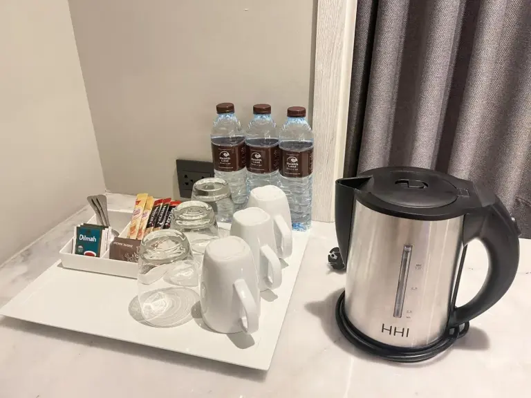 In-room tea and coffee amenities at Health Land Resort & Spa Pattaya with water bottles, cups, and electric kettle