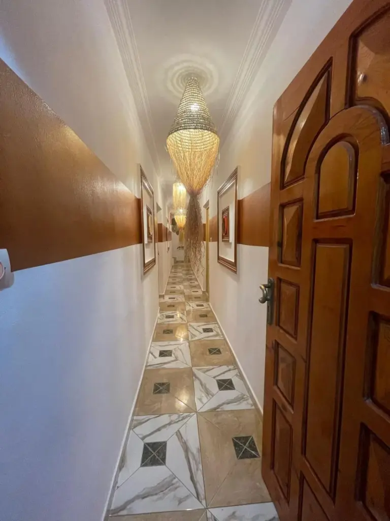 Decorative hallway inside Heaven Surf Camp in Agadir with patterned floor, wall art, and hanging lights