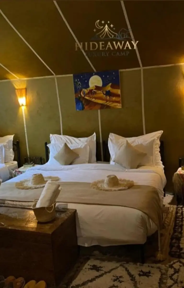 Cozy bed area with art in a tent at Hideaway Luxury Camp